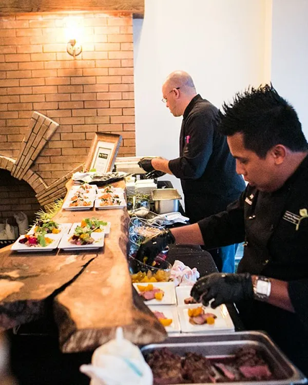 Chefs plating gourmet appetizers at a live catering station