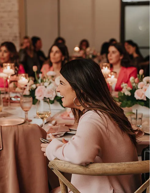 Guests enjoying a candlelit dinner with pink floral décor