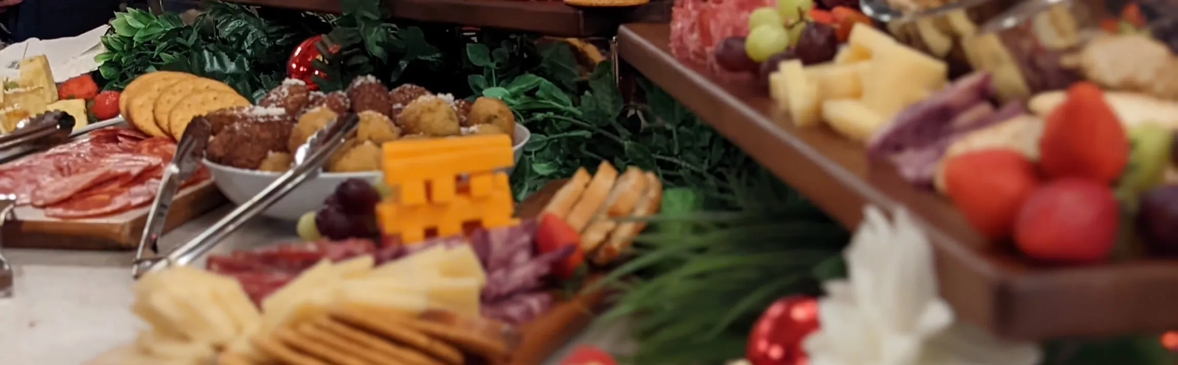 Festive charcuterie boards with cured meats, cheeses, crackers, fruit, and holiday greens