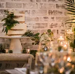 Two-tier semi-naked wedding cake with greenery and candlelight