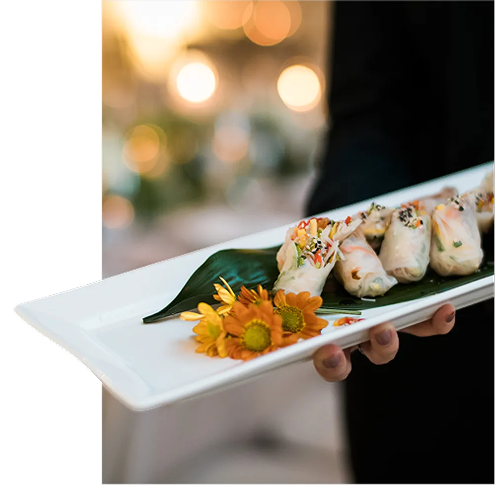 Server presenting fresh spring roll hors d'oeuvres at a catered event