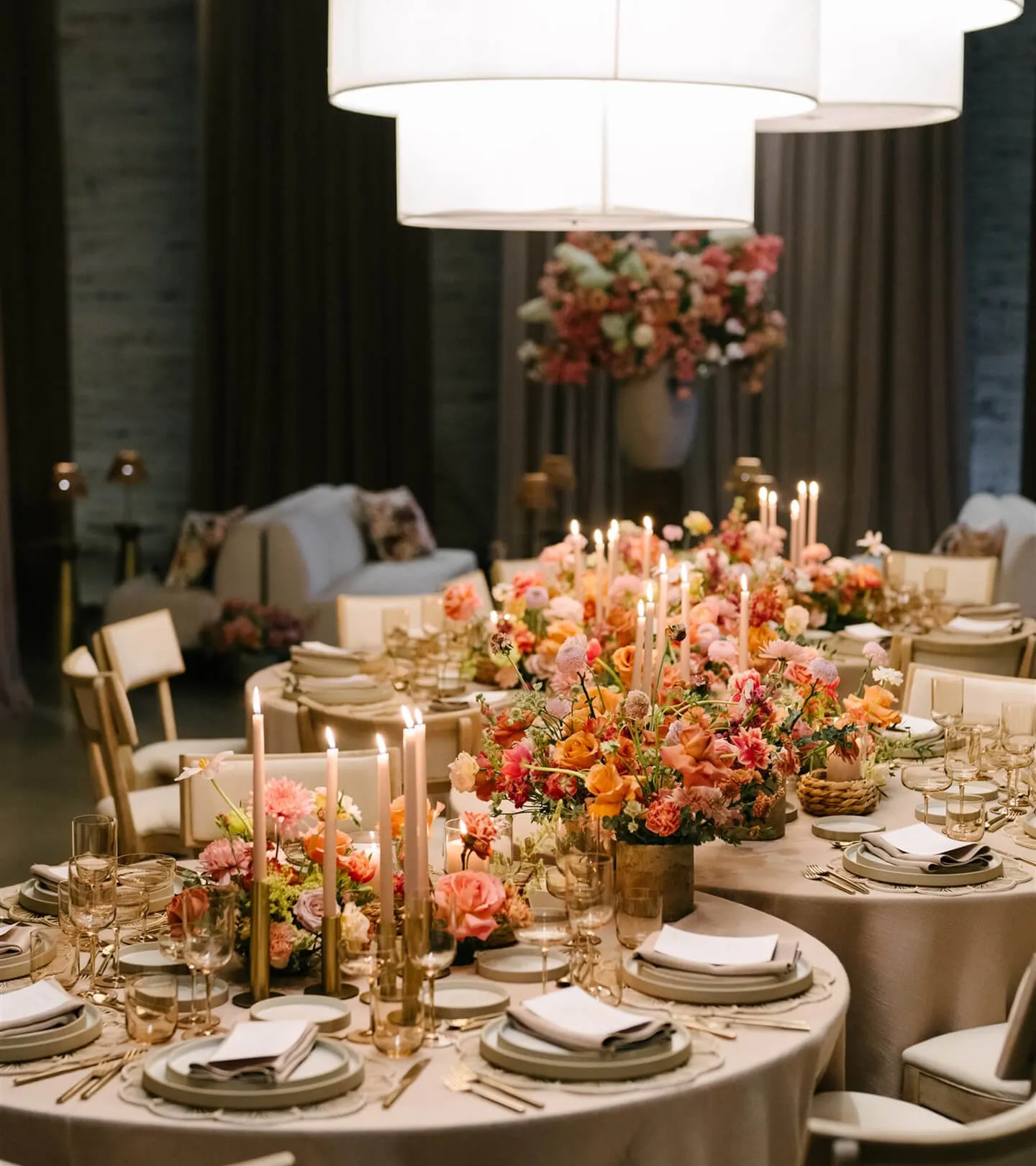 Candlelit reception tables with peach floral centerpieces and formal place settings